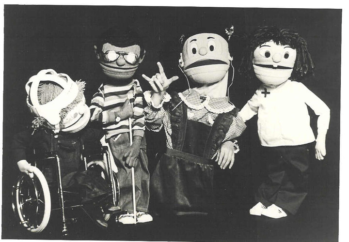 4 puppets are pictured, Mark who has CP and uses a wheelchair, Reanaldo who has a visual impairment, Many who has a hearing impairment and is making the sign for I Love You and Ellen Jane who has Down syndrome.