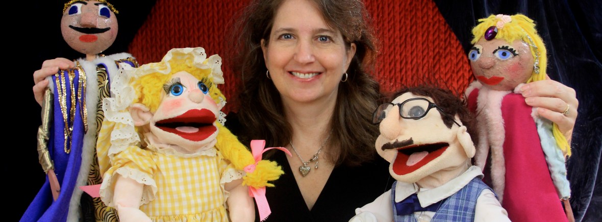 Director Nancy Riggs surrounded by puppets