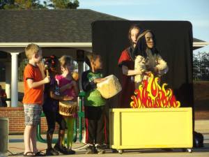 children with instruments on stage with the puppeteer and Chief Gray Eagle puppet