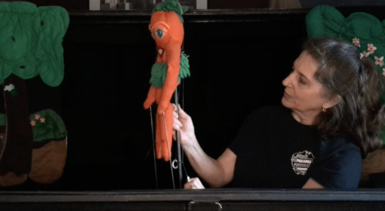 Puppeteer holding a carrot rod puppet